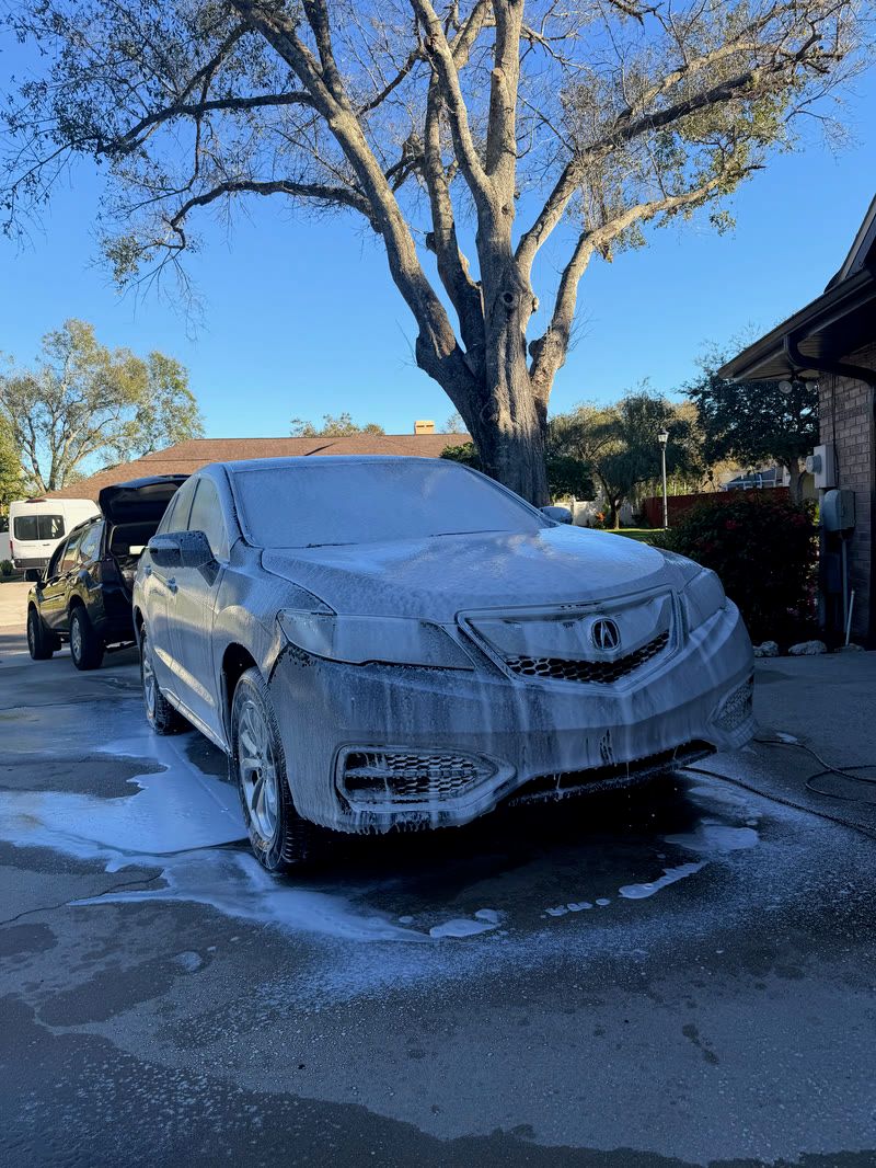 Sedan covered in foam during an exterior maintenance wash